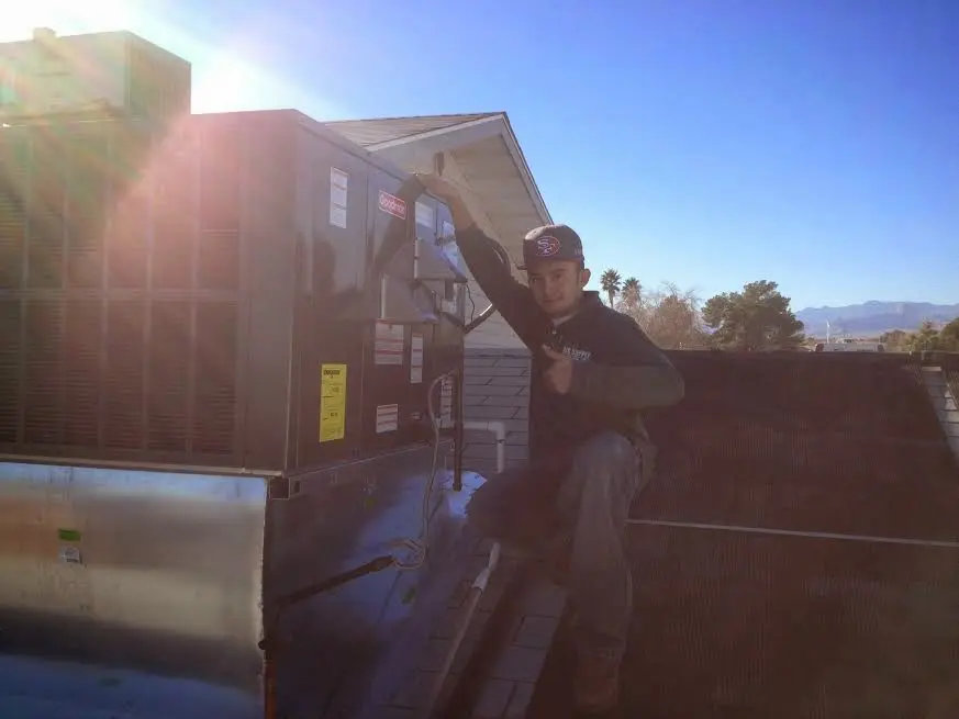 HVAC technician performing AC Tune-Up on a rooftop unit in Tucson Mountains